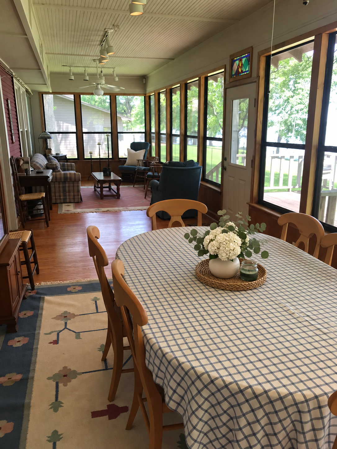Sunroom with walls of windows opening to the breakfast area